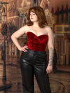 model wearing a red velvet bustier corset top with leather pants in holiday street scene