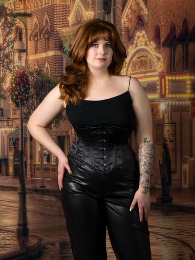 cute corset model wearing a cs 201 black satin waist training corset with black leather pants and camisole