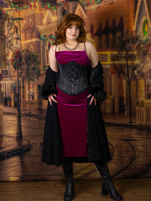 cute corset model wearing the cs345 black satin waist training corset with a dark fuchsia velvet dress