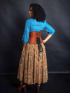 Back lace up corset view  of Model wearing a turquoise beaded shirt and multi colored skirt and a cinnamon brown brocade waist training corset