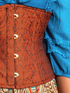 close detail photo of a Model wearing a turquoise beaded shirt and multi colored skirt and a cinnamon brown brocade waist training corset