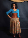 Model wearing a turquoise beaded shirt and multi colored skirt and a cinnamon brown brocade waist training corset