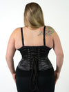 back lace up corset view of a plus size corset model wearing a cs411 standard romantic curve waist training black corset with a black bra and black leggings