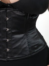 close up detail view of a plus size corset model wearing a cs411 standard romantic curve waist training black corset with a black bra and black leggings