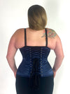 curvy plus size model wearing a black bra and leggings with a navy satin longline corset back lace up corset view