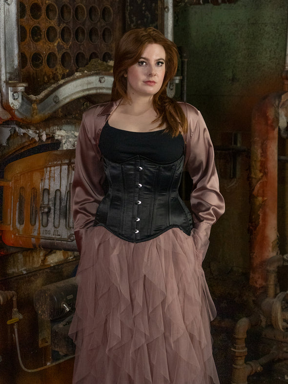 Curvy model wearing an extreme curve waist training corset in black satin over a tulle skirt and jacket cs479 longline