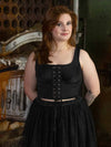 Model wearing a black lace up corset top with a tulle skirt paris by orchard corset