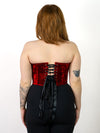 back lace up view of a cute smiling model in a red wine velvet bustier corset top