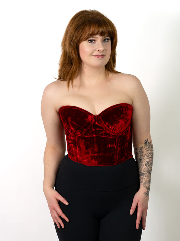 cute smiling model in a red wine velvet bustier corset top